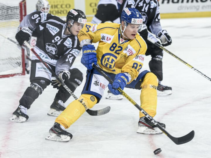 Turku`s Henrik Larsson, left, against Davos' Harri Pesonen during the game between TPS Turku and HC Davos, at the 93th Spengler Cup ice hockey tournament in Davos, Switzerland, Sunday, December 29, 2019. (KEYSTONE/Melanie Duchene)
